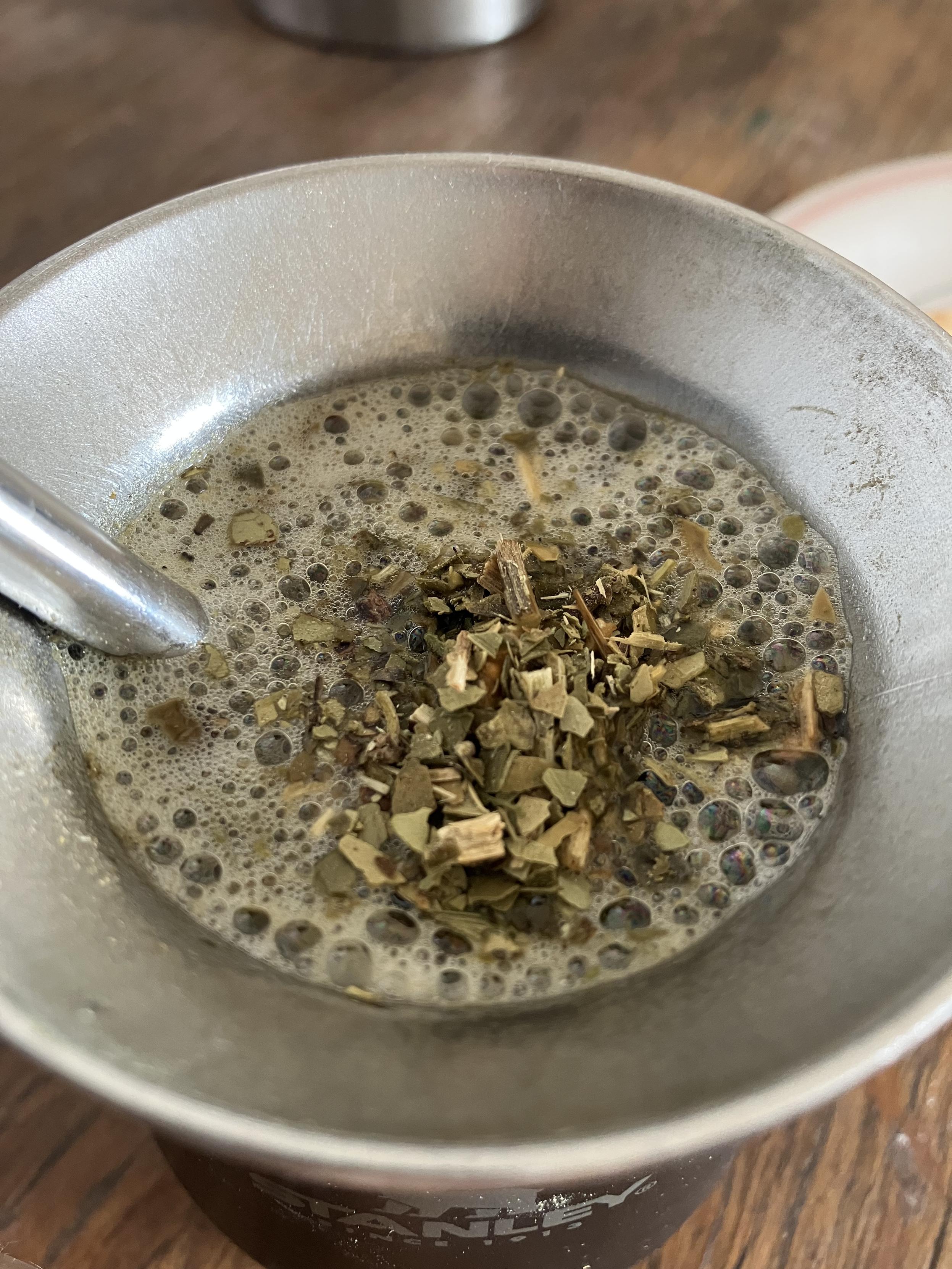 Un cazo de metal con mate bien cebado, está muy burbujeante y sobresale un poco de yerba.