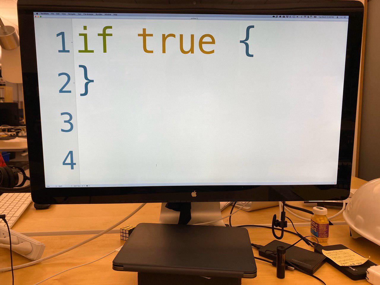 A monitor displaying a text editor fullscreen, with the text really huge. It's so enlarged it can only display four lines in the whole monitor, and the text is 
if true {
}

Big if true.